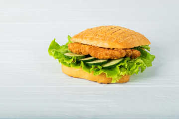 Pressed and toasted double panini with ham and cheese served on sandwich paper on a wooden table