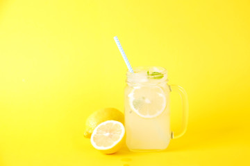 Ice cold lavander lemonade, lemon, straw, mint. Classic virgin mojito cocktail, non alcoholic drink with ice in vintage mason jar glass, bright pink isolated background. Copy space, top view close up.