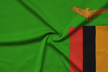 Zambia flag  is depicted on a sports cloth fabric with many folds. Sport team banner