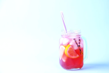 Red berry lavander lemonade, lemon & straw. Virgin strawberry mojito, non alcoholic cocktail with ice in vintage mason jar glass, Isolated on pale blue white background. Copy space, top view, close up