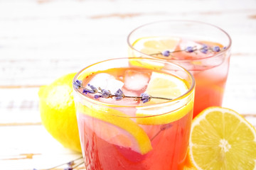 Red berry lavander lemonade, lemon, straw. Virgin strawberry mojito, non alcoholic cocktail with ice in vintage drinking glass, Isolated on pale grunged wood background. Copy space, top view close up