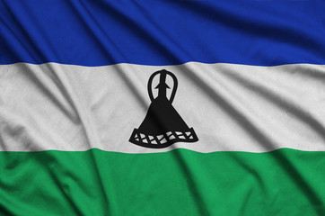 Lesotho flag  is depicted on a sports cloth fabric with many folds. Sport team banner