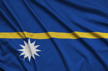 Nauru flag  is depicted on a sports cloth fabric with many folds. Sport team banner