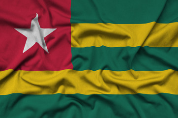 Togo flag  is depicted on a sports cloth fabric with many folds. Sport team banner