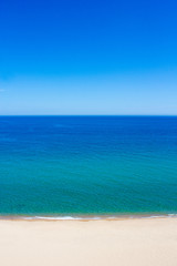summer and travel background - aerial view of sandy beach, transparent sea and blue sky