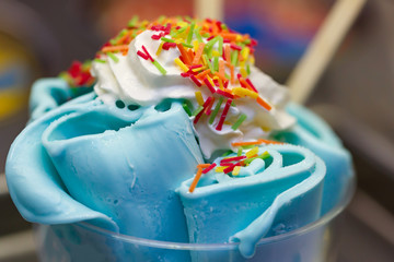 Roll ice cream is made by hand on the freezer. Sweet dessert made with natural colored caramel and blue dye.