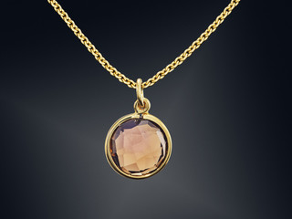 Golden necklace with gemstone isolated on black