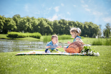 Two happy kids sitting on picnic in the park
