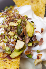 Roll ice cream is made by hand on the freezer. Sweet dessert made with potato chips and ground nuts of pistachios.