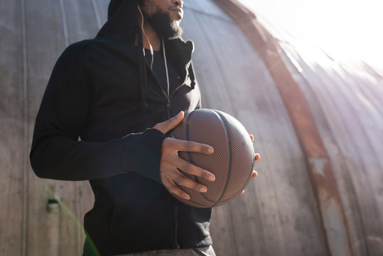 Cropped Shot Of African American Man Holding Basketball Ball On Street