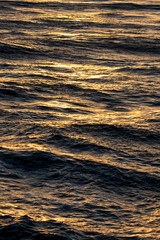 Golden sunset reflecting on ocean waves 