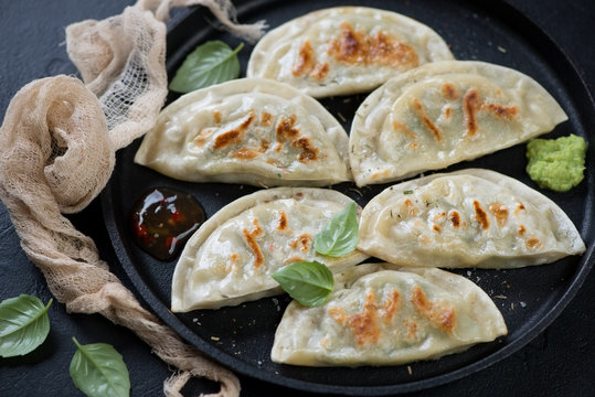 Closeup of fried korean potstickers served on a metal tray, selective focus, studio shot