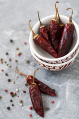 Red sharp dried dried chillies of pepper and pepper in grains on a vintage gray background