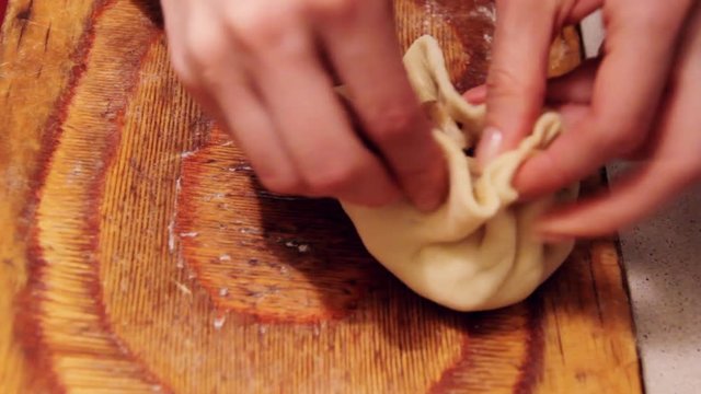 Women prepare vak belyash - bashkir national homemade meat pies , close up shot. Meat and potato inside, dough is twisted. Cooking at home.