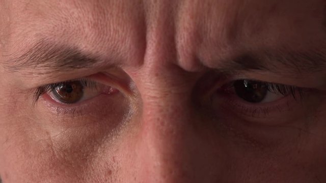 Extreme close up of male eyes looking at digital tablet