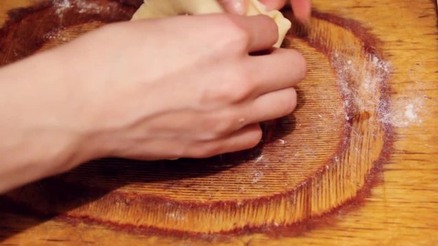 Raw Vak belyash - bashkir national homemade meat pies on wood chopping board at home kitchen. Preparation making from raw dough process.