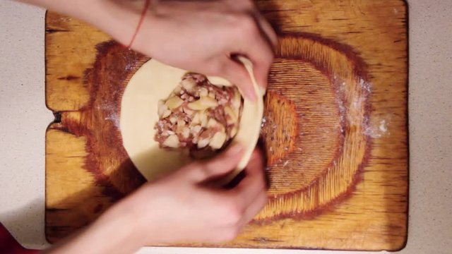 Women prepare vak belyash - national homemade meat pies. Traditional russian meat pies belyashi. belyashes on a on wood chopping board. Russian, Bashkir and Tatar cuisine. Top view.
