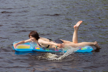 cheerful woman on an inflatable mattress