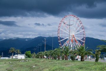 Batumi bulvar with ferris wheel before storm in summer day