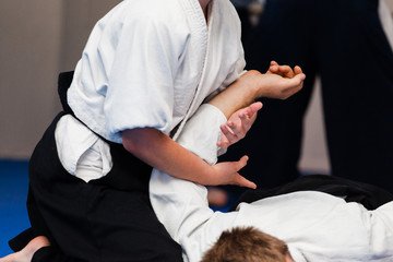 Aikidoka uses the technique joint lockon the opponent during the training of aikido - obrazy, fototapety, plakaty