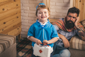 Handsome son and sick father playing doctor sitting on floor