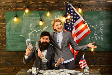 man and woman with money standing over USA flag. happy and embrace.