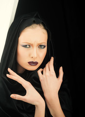 Black Friday concept. Gothic fashion and beauty. Makeup look and skincare sensual of girl. Fashion model with makeup of mysterious girl. Sexy woman in black hood. Religion and death concept.