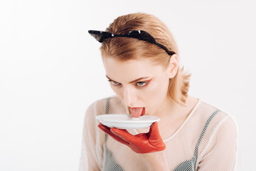Girl in kitten ears and red gloves with yoghurt isolated on white. Cat woman eat sour cream. Dieting and health. Ecology product and heath. Sexy cat woman lick milk from plate. Food and drink.