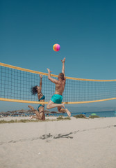 Couple have fun playing volleyball. Young sporty active couple beat off volley ball, play game on...