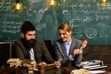 Old books on a round wooden table. Teacher always adapt. International student making individual online testing. Teacher is skilled leader. learning. enthusiastic and caring