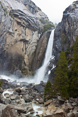 Obraz premium Waterfall in Yosemite, with trees and rocks