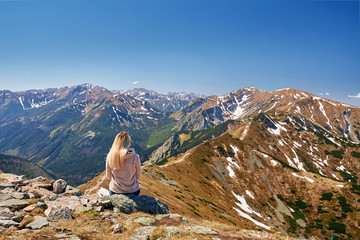 a man sits, dreams against the backdrop of the mountains and the sky
