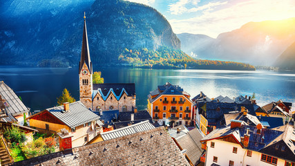 Scenic view of famous Hallstatt mountain village with Hallstatter lake See in beautiful golden...