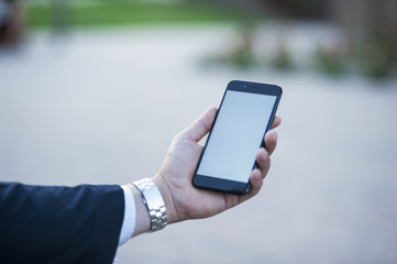 Touch screen of a mobile phone, in the hand of a businessman. Photo for Mock Up