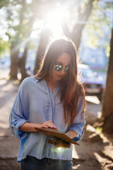 Girl is holding a clutch bag.