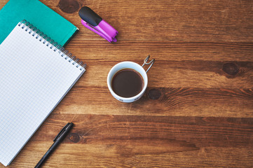 open notebook with pen and coffee on wooden table