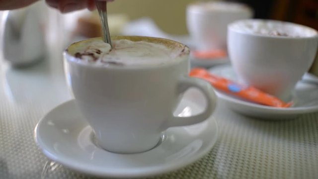 The spoon at the cup of coffee cappuccino