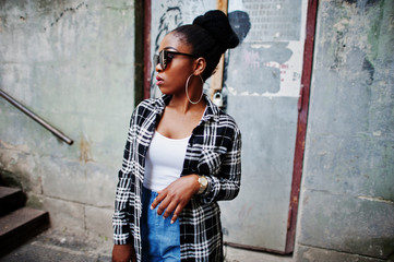 Hip hop african american girl on sunglasses and jeans shorts. Casual street fashion portrait of...