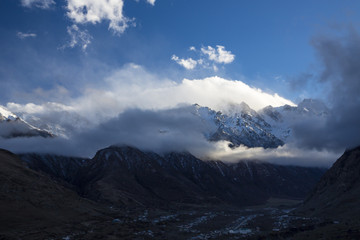 Plakat Горный пейзаж. Вершины в белых облаках, Красивый вид на живописное ущелье, панорама с высокими горами. Природа Северного Кавказа, отдых в горах