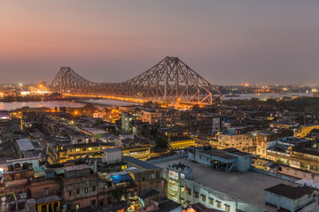 Beautiful view of Kolkata city with a Howrah bridge on the river Hooghly at twilight. - 210230989
