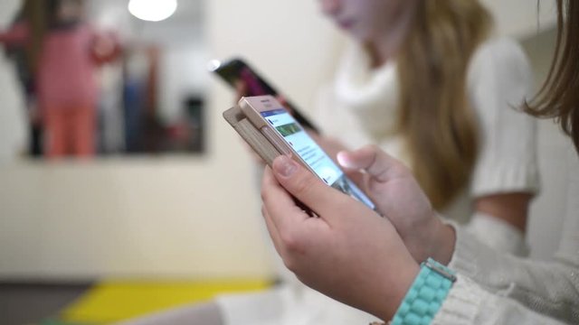 Children with their Smartphones and mobile phone in school class room shatting