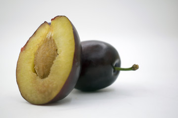Isolated plums. Whole and a half of blue plum fruit isolated on white background, with clipping path