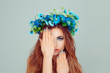 Beauty girl hand on face blue flowers on head in set combination with her nails