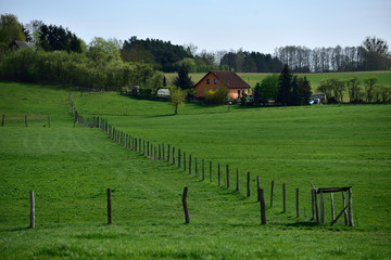 A small country house with a field and a farm.