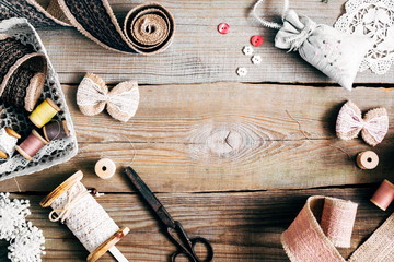 Background with sewing tools and colored tape. Tools for sewing, vintage scissors, buttons, ribbon, pins, on an old wooden table. Flat lay, top view, copy space 