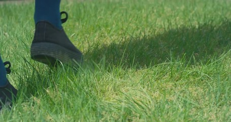 Feet of young woman walking in garden