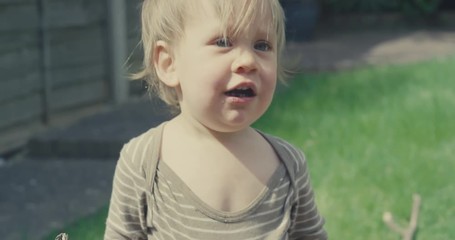 Little toddler boy screaming after eating soil in the garden