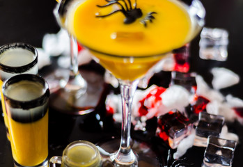creepy halloween party cocktails with blood, spiders and ice cubes