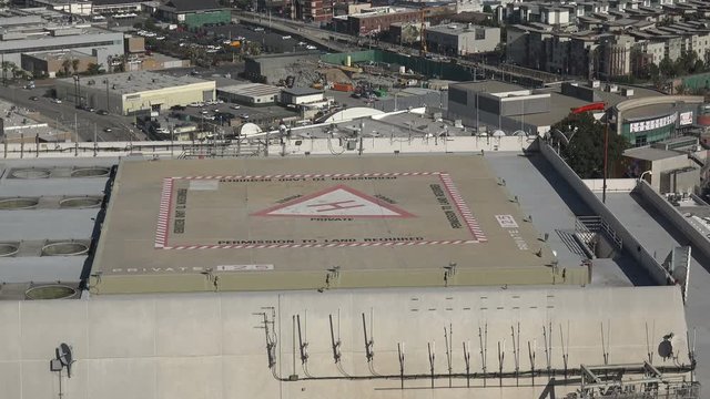 Windsock blowing at a heliport on top of a tall city building