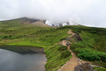 Narrow dirt path leading to steam vents on Asahidake, an active volcano in Hokkaido, Japan - Powered by Adobe